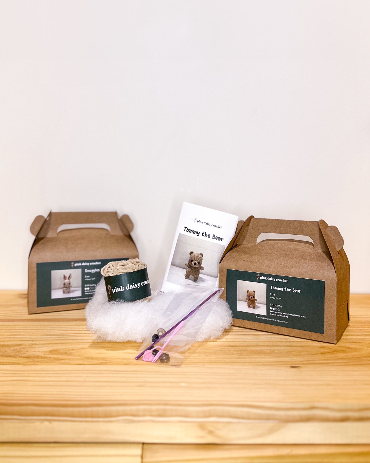 Two kraft crochet-kit boxes with yarn, hook, and a printed pattern